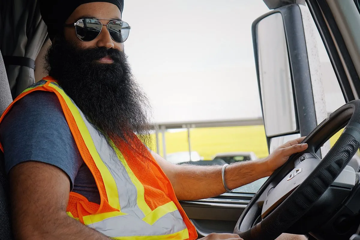 JK Express driver in the cab wearing a safety vest