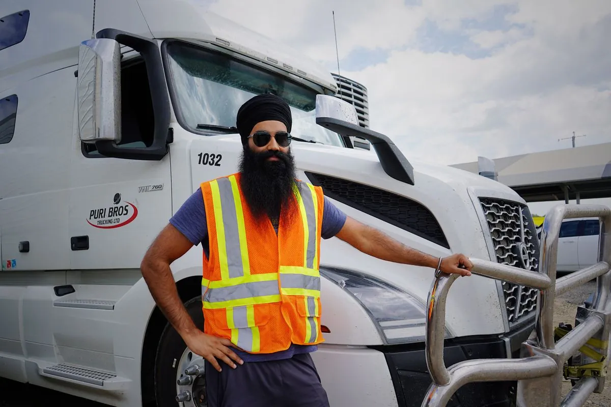 JK Express driver in a high-visibility vest beside his truck