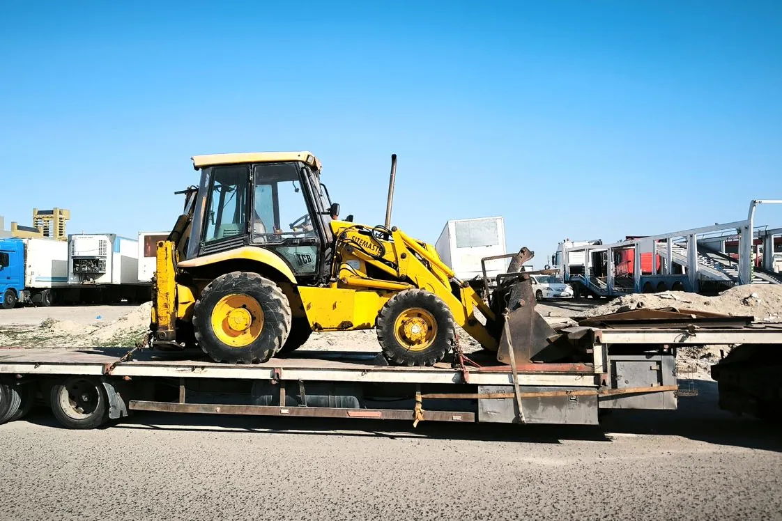 Yellow construction equipment on a low-bed trailer