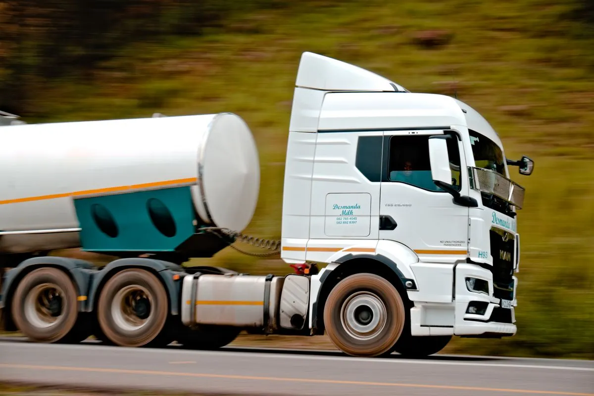 White tanker truck in motion on a highway